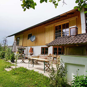 Gemütliches Einfamilienhaus mit Garten, Terrasse und ländlicher Holzfassade im Grünen.