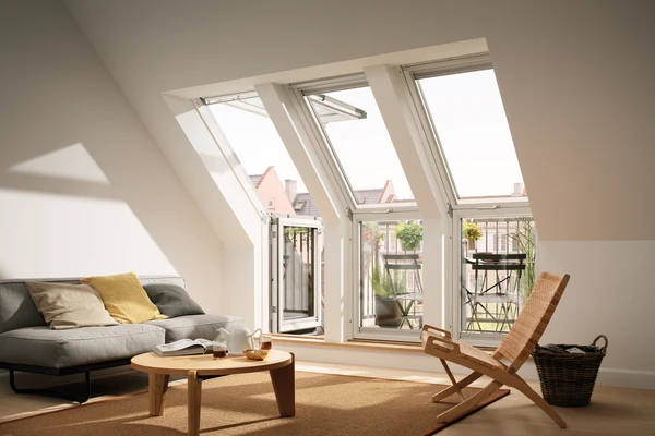 Helles Dachgeschoss-Wohnzimmer mit Sofa, Couchtisch und Balkonfenstern