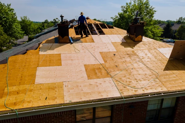 Dachdecker verlegt Sperrholzplatten bei Dachsanierung auf Flachdach